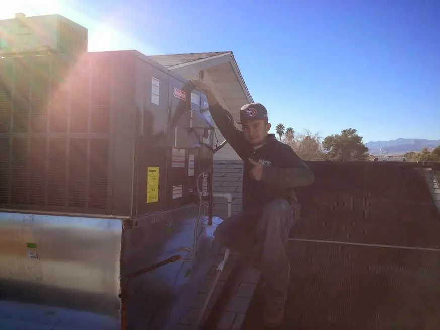 HVAC technician performing AC Tune-Up on a rooftop unit in Alhambra
